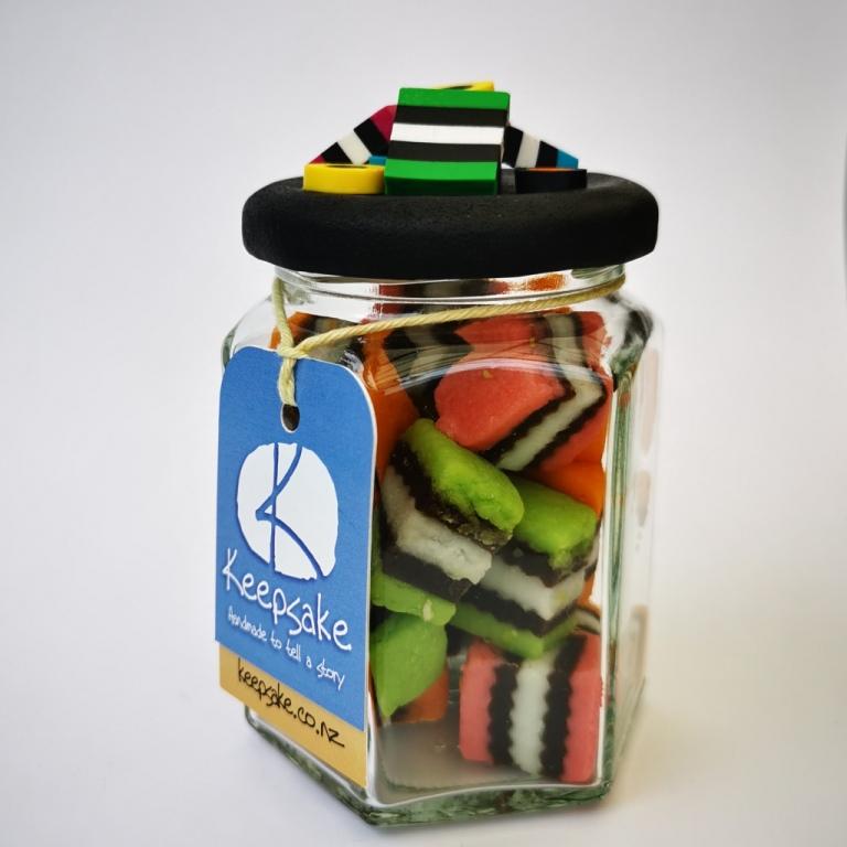 270ml glass hexagonal lolly jar hand-decorated in New Zealand, with  an air-tight lid decorated with polymer clay licorice allsorts. Filled with licorice allsorts.