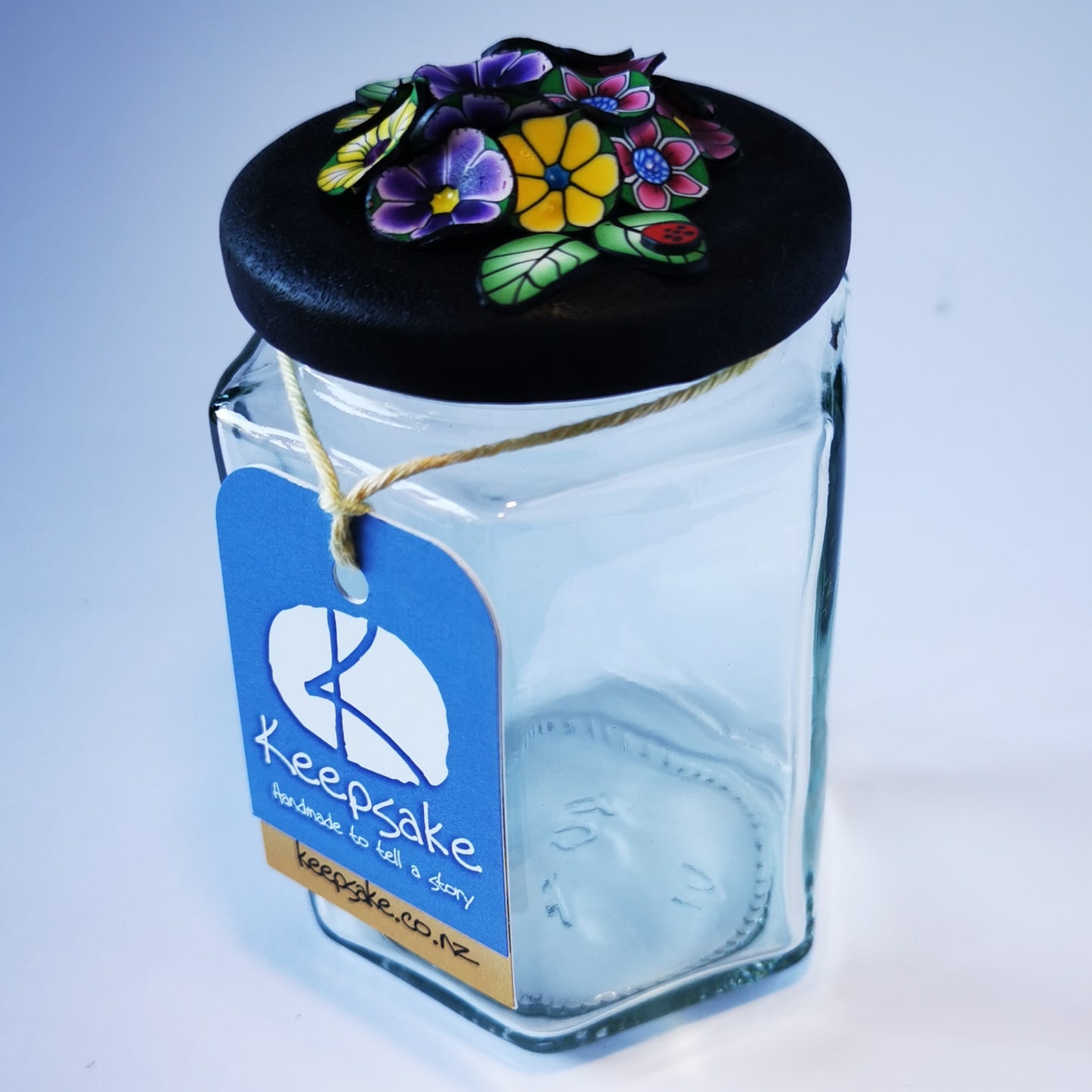 270ml glass hexagonal  jar and lid hand-decorated in New Zealand, with  an air-tight lid decorated with colourful polymer clay flowers. Ready to be filled with fudge, sweets or other treasures.