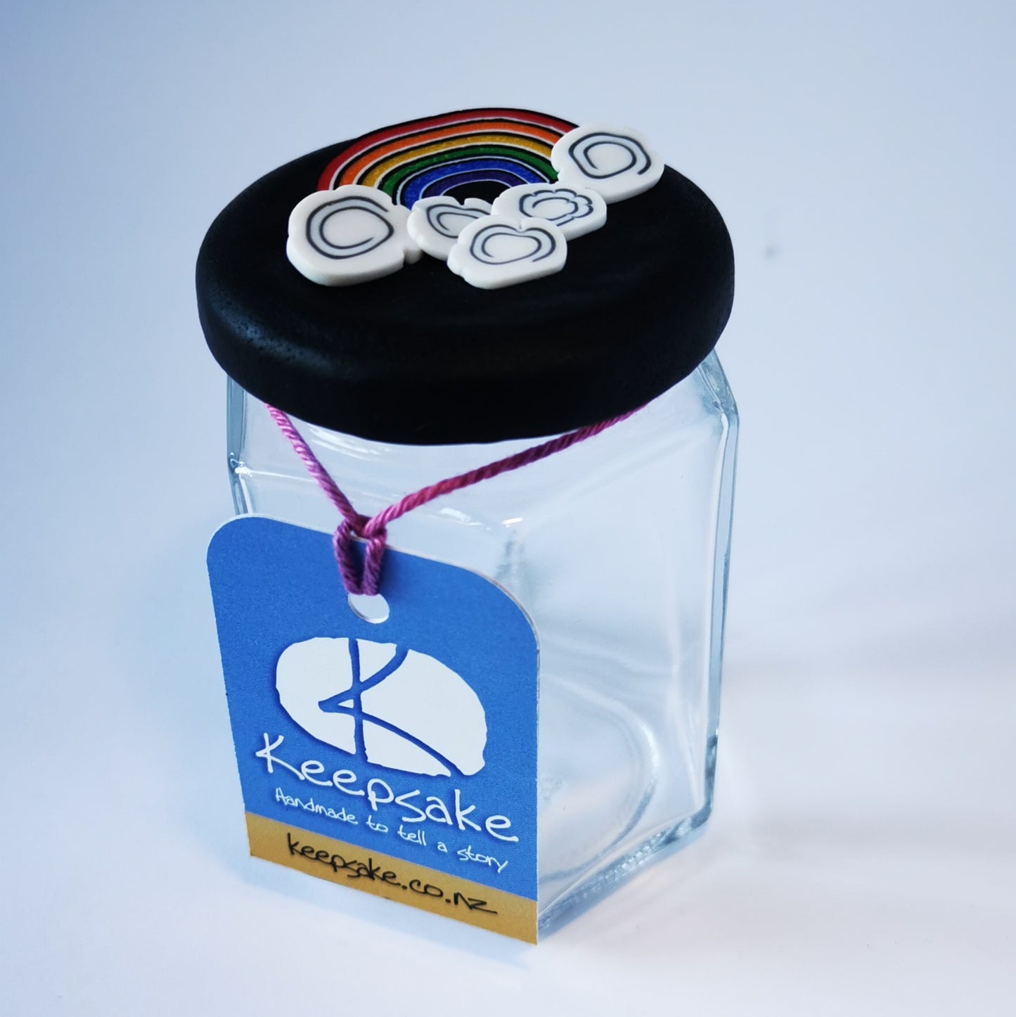 185ml glass hexagonal jar and lid hand-decorated in New Zealand, with an air-tight lid decorated with a polymer clay rainbow and clouds. Ready to be filled with gold, sweets or other treasures.