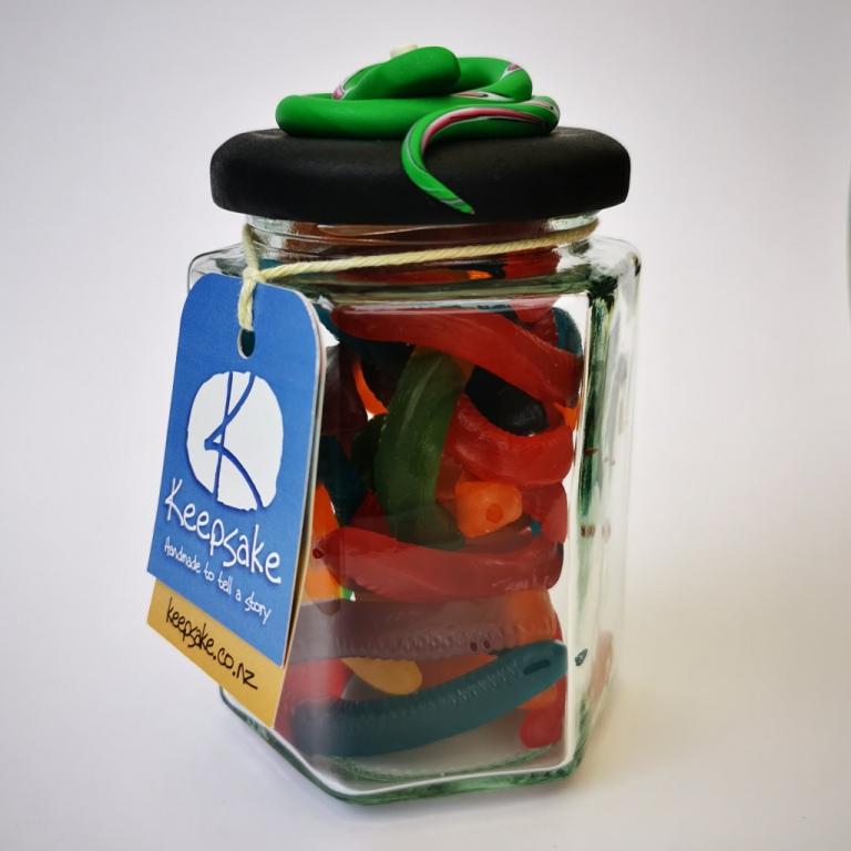 270ml glass hexagonal lolly jar hand-decorated in New Zealand, with  an air-tight lid decorated with a  polymer clay snake. Filled with snake lollies
