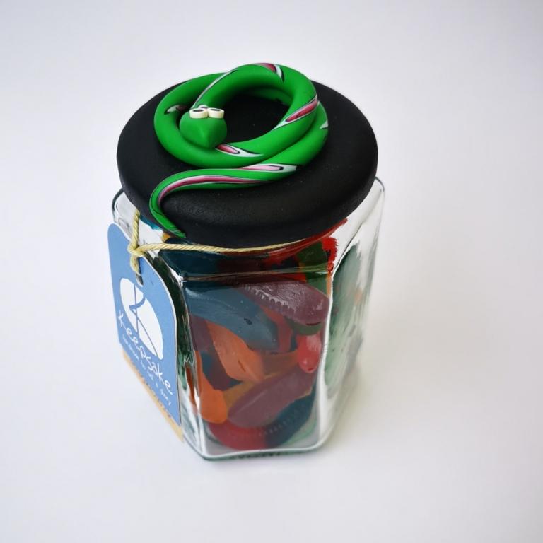 270ml glass hexagonal lolly jar hand-decorated in New Zealand, with  an air-tight lid decorated with a  polymer clay snake. Filled with snake lollies