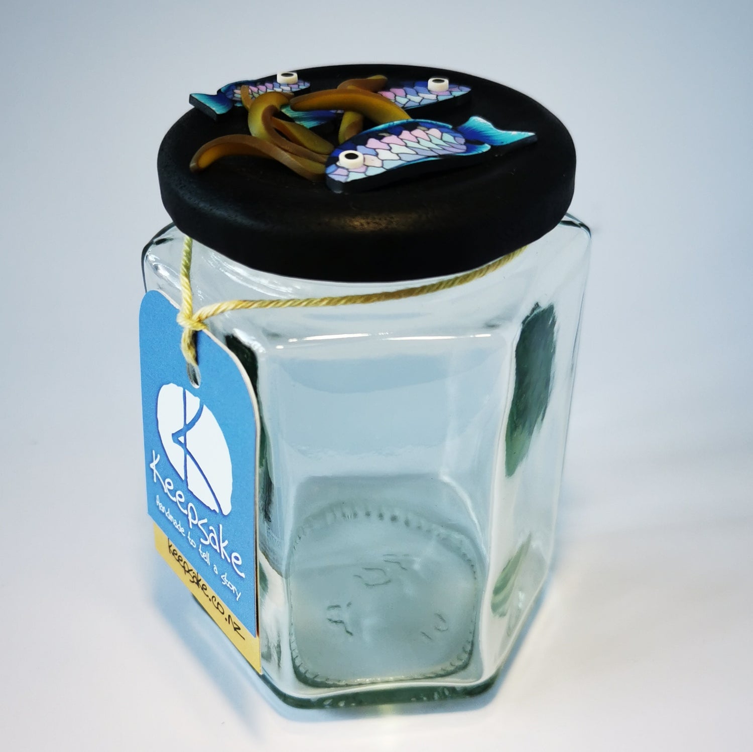 270ml glass hexagonal  jar and lid hand-decorated in New Zealand, with  an air-tight lid decorated with polymer clay snapper fish and kelp. Ready to be filled with kelp powder, sweets or other treasures.