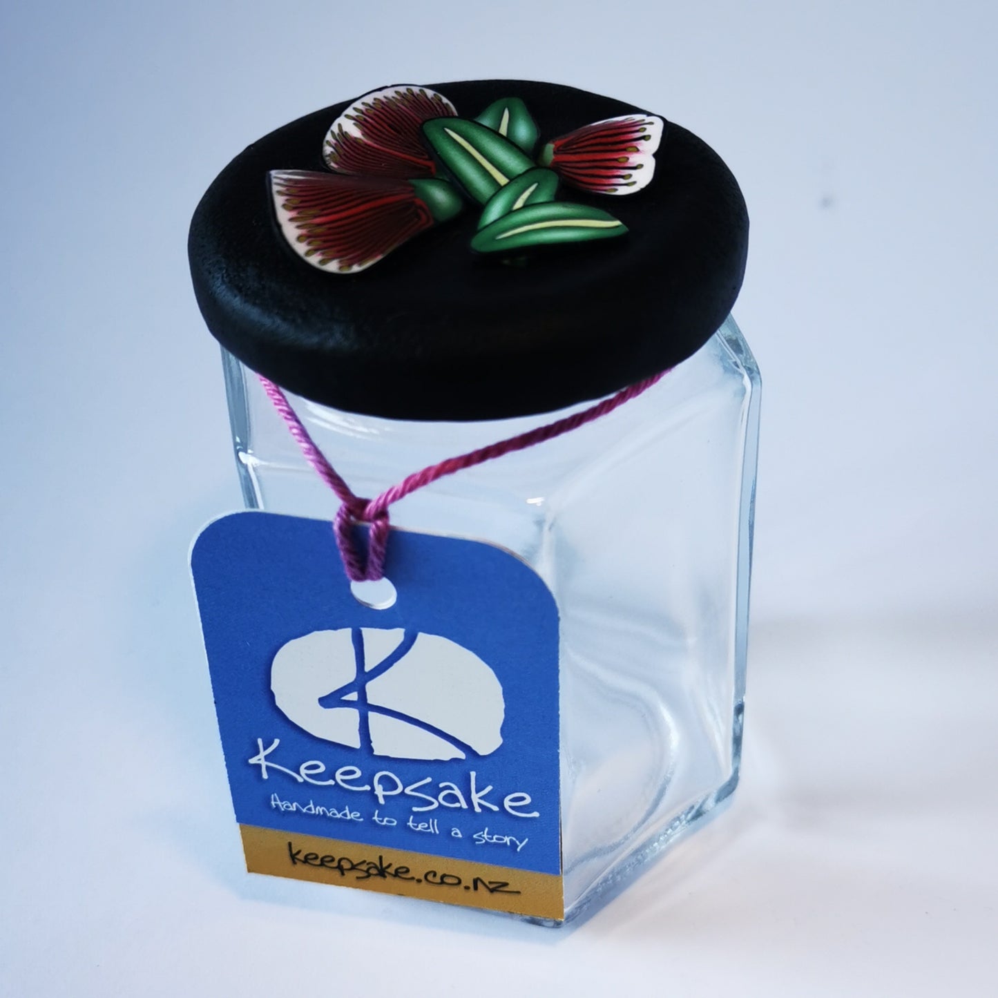 185ml glass hexagonal  jar and lid hand-decorated in New Zealand, with  an air-tight lid decorated with polymer clay pohutukawa flowers and leaves. Ready to be filled with fudge, sweets or other treasures.