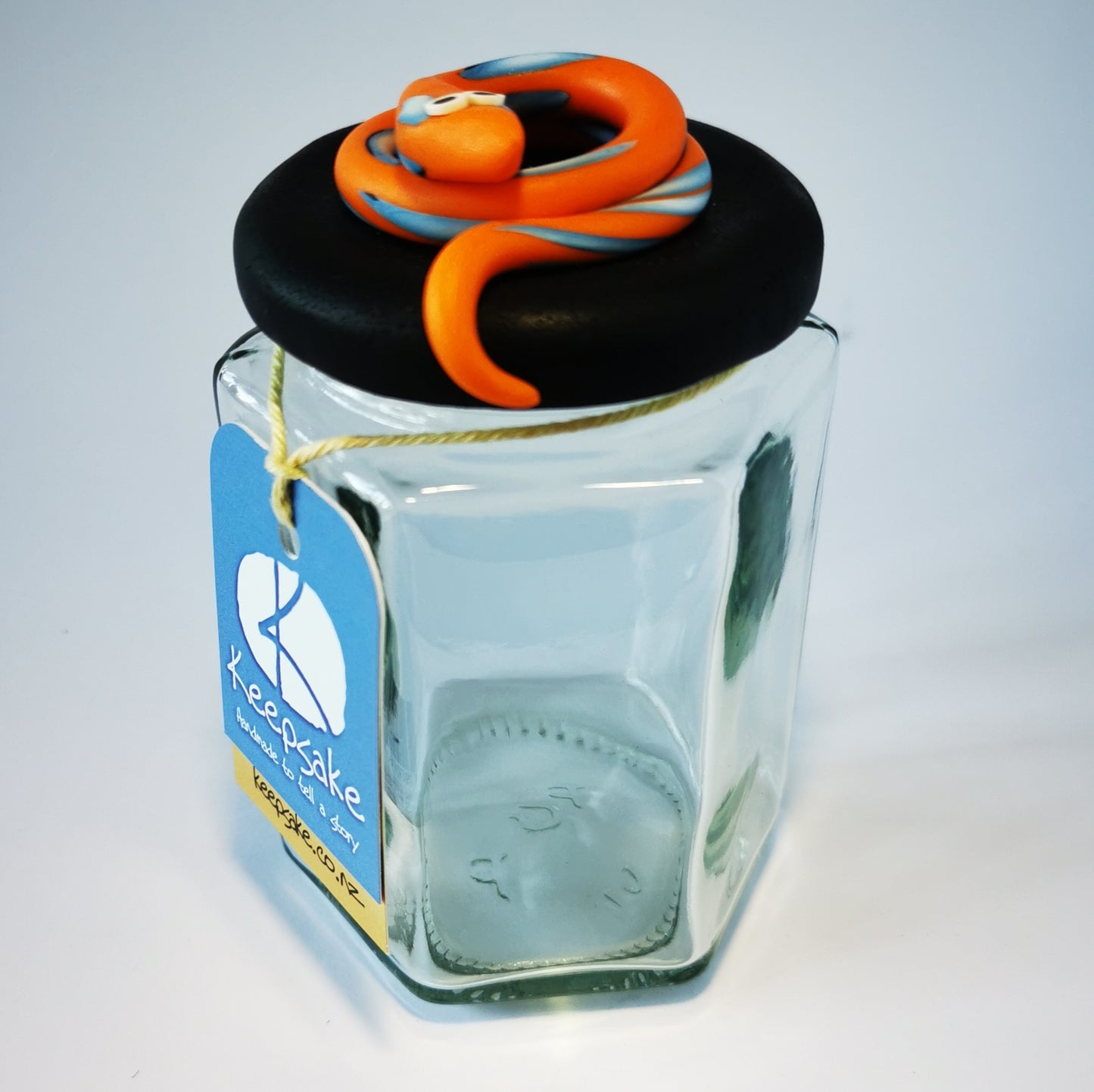 270ml glass hexagonal  jar and lid hand-decorated in New Zealand, with  an air-tight lid decorated with an orange snake. Ready to be filled with jelly snakes, sweets or other treasures.